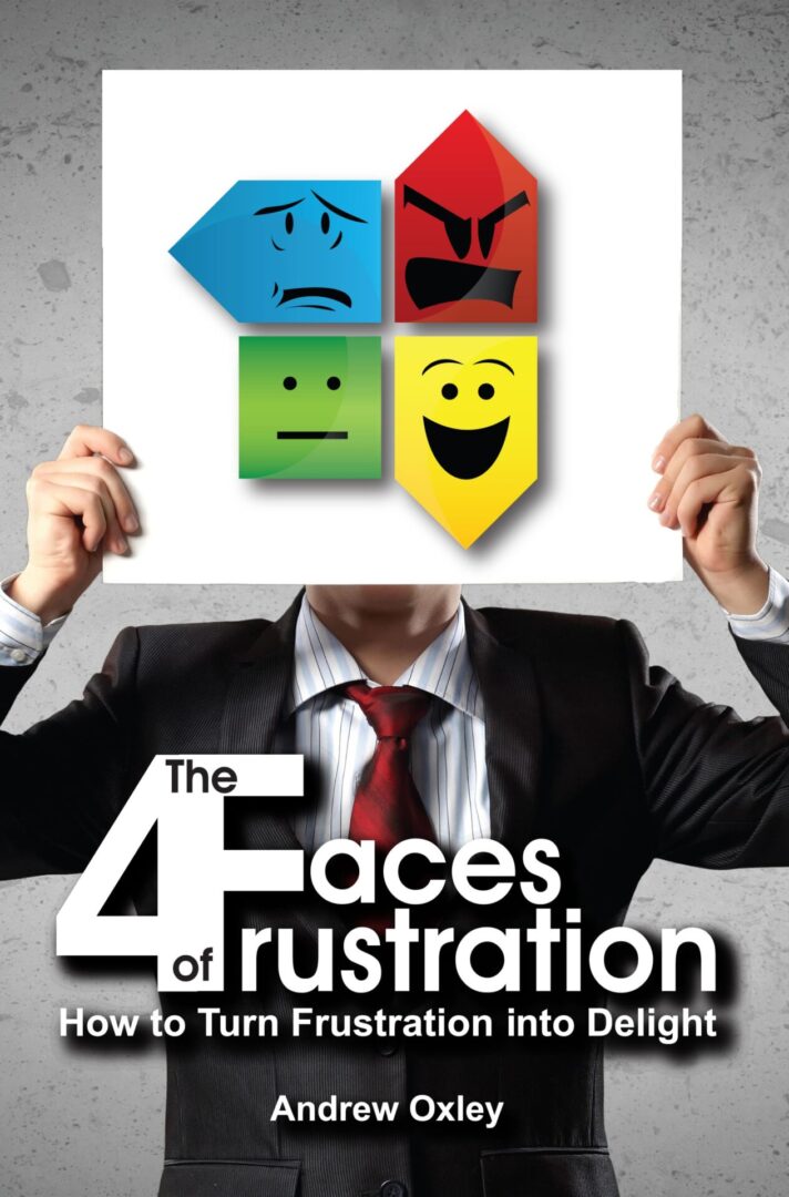 A person holding a book titled 'The 4 Faces of Frustration' by Andrew Oxley with icons representing different emotions on the cover.