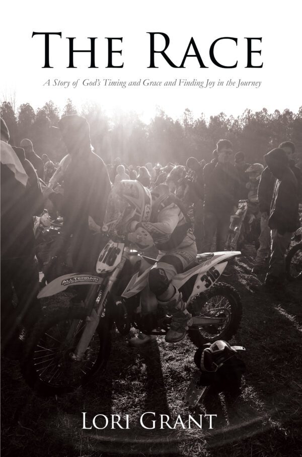 Motorcyclist at the starting line, bathed in sunlight, on the cover of 'The Race' by Lori Grant.