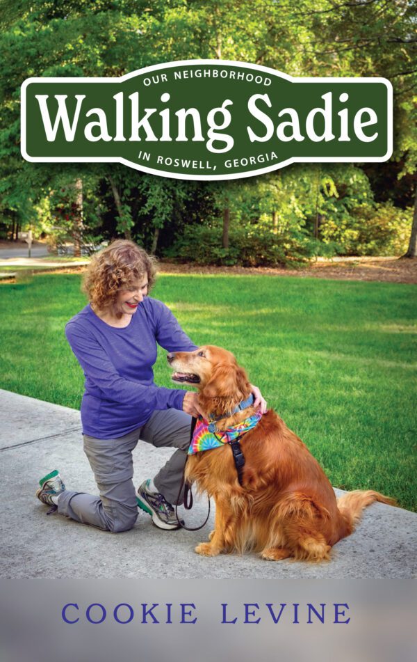 A woman kneeling and smiling at a golden retriever on a neighborhood sidewalk with the book title "Walking Sadie" by Cookie Levine.