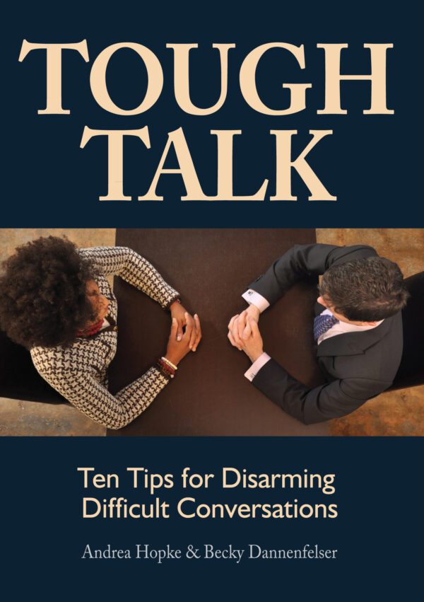 Two individuals engaged in a serious conversation at a table with the product "Tough Talk - Bulk Orders" above them.