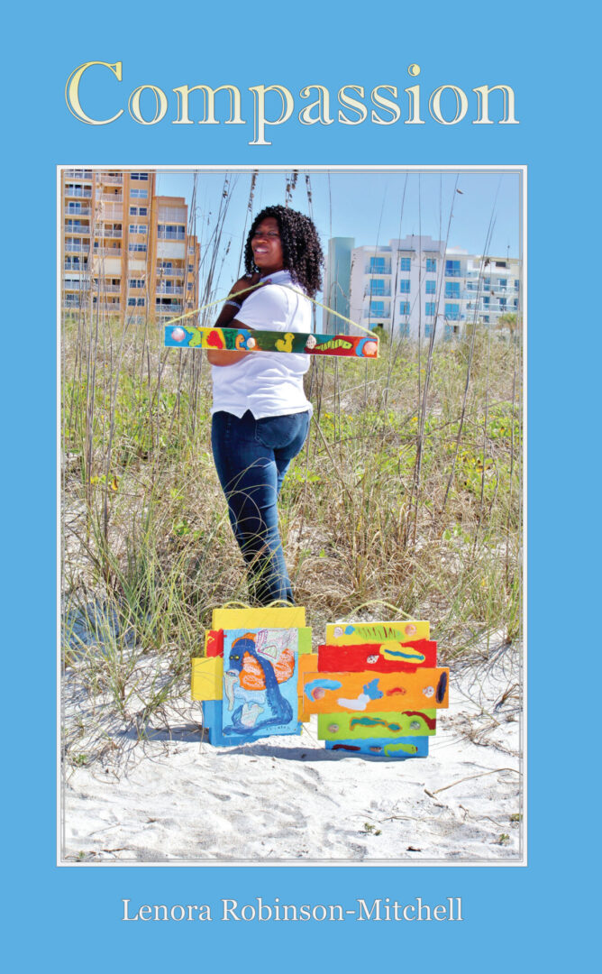 A woman holding a skateboard stands on a beach with a colorful Compassion in front of her, against a backdrop of tall buildings.